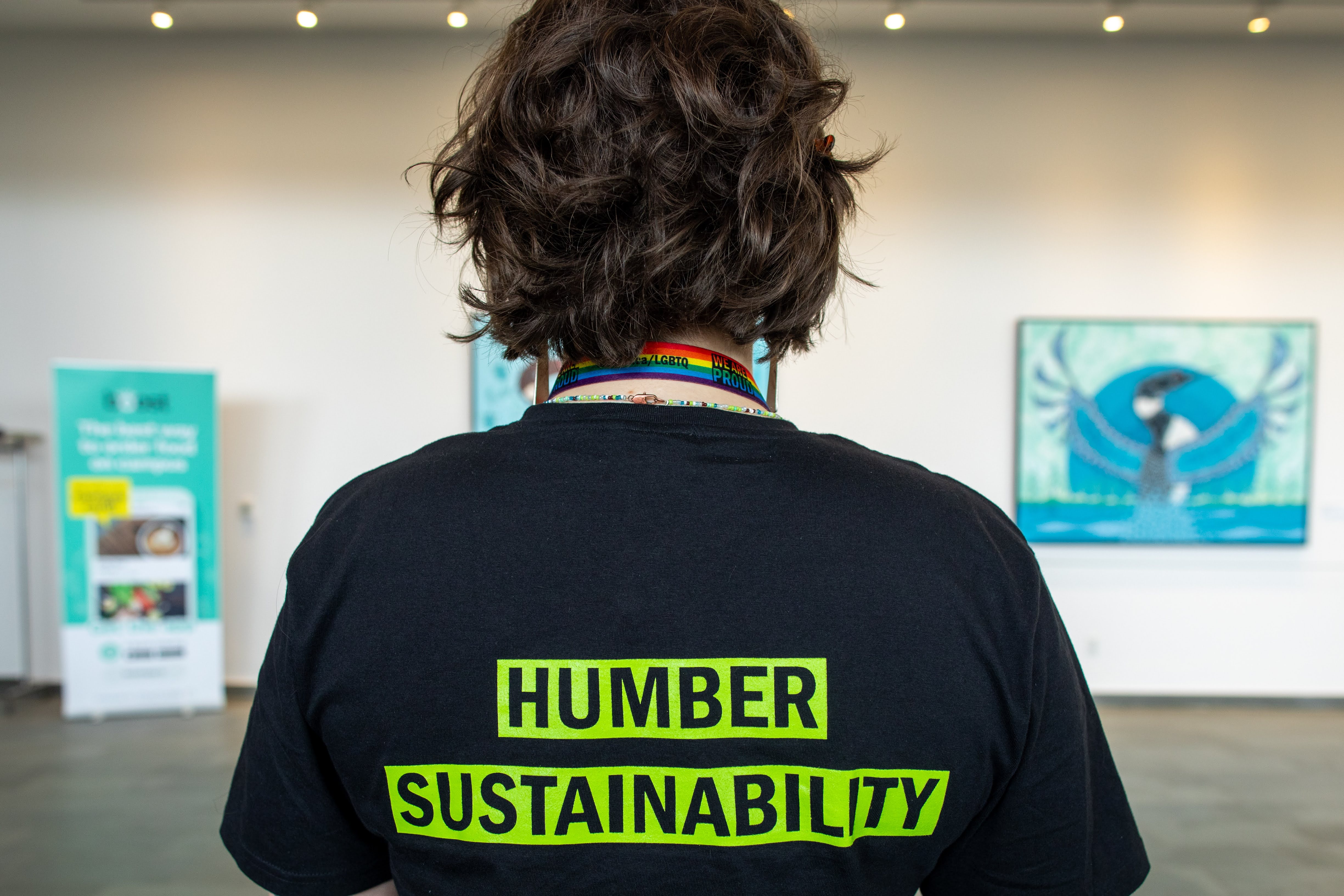 A person wearing a Humber Sustainability shirt with their back to the camera.