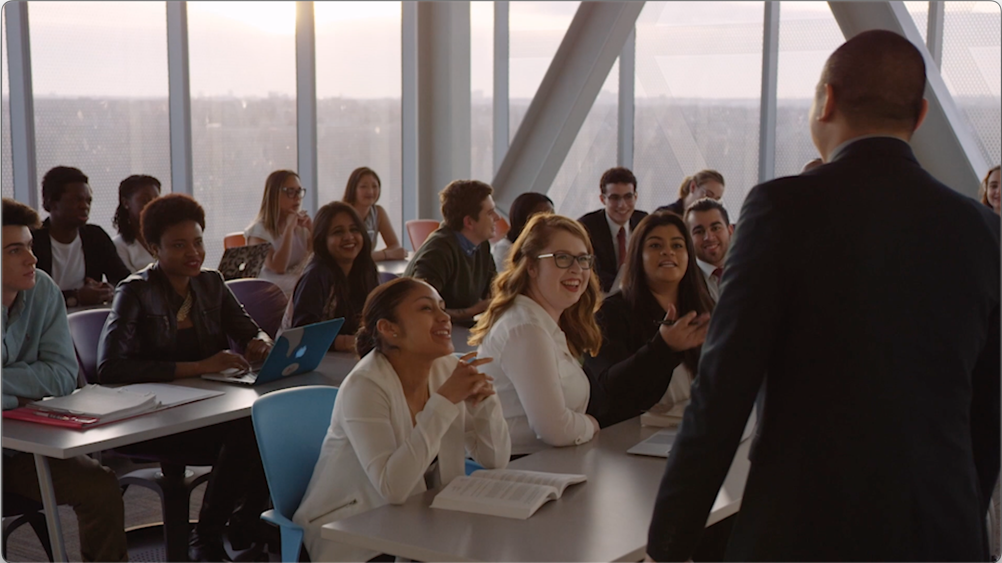 A group of students sit in a classroom facing a speaker.