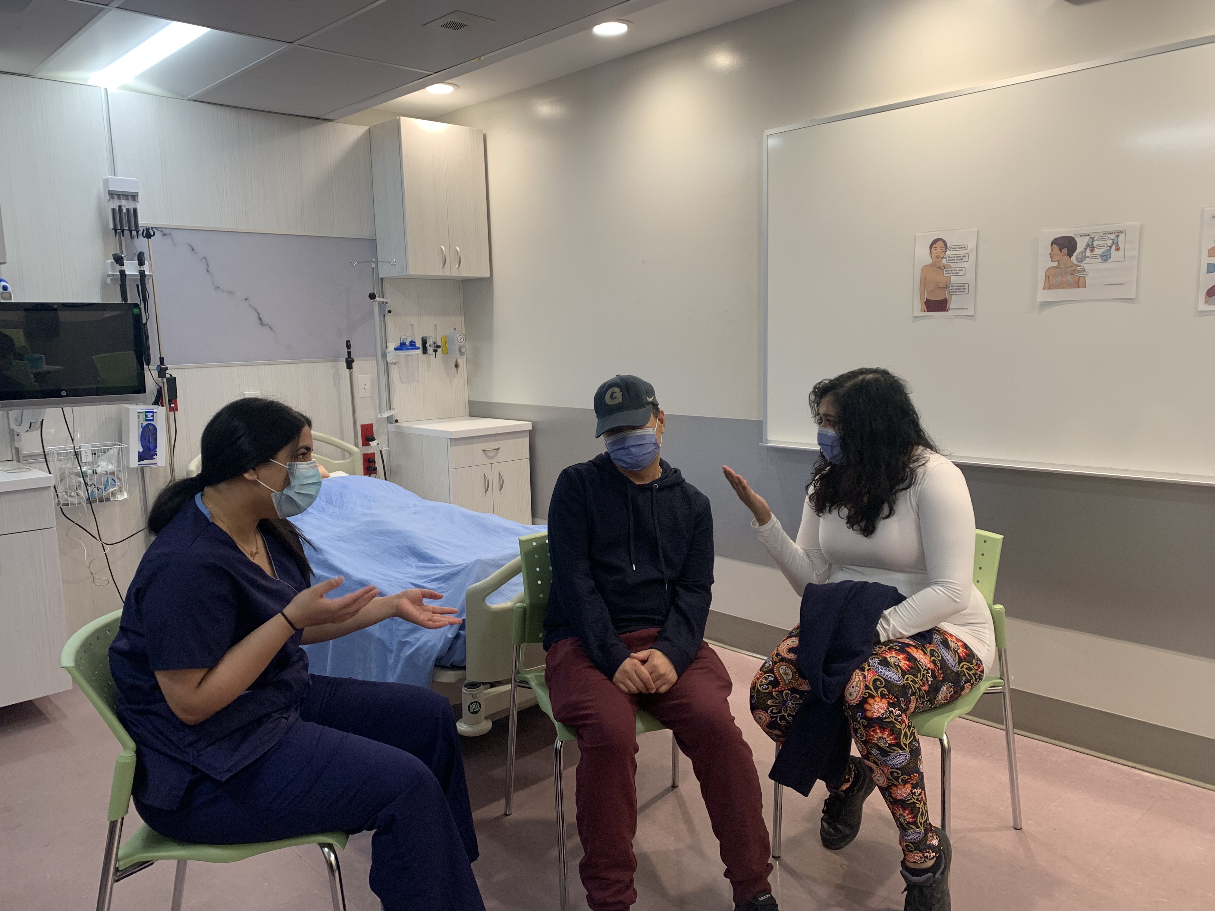 Three students roleplay a scenario involving a patient at a hospital.