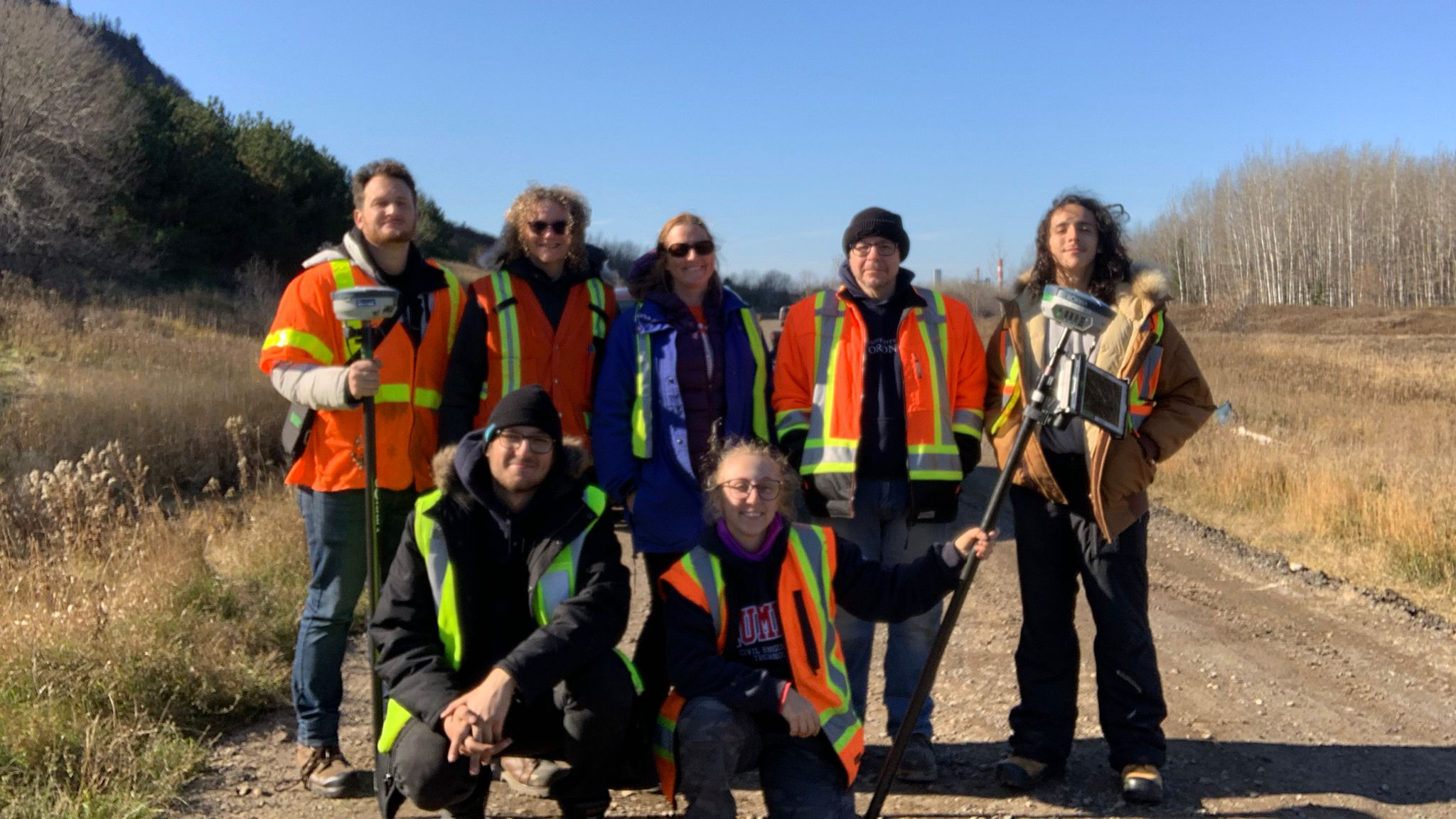 Group of researchers wearing neon orange safety vests.